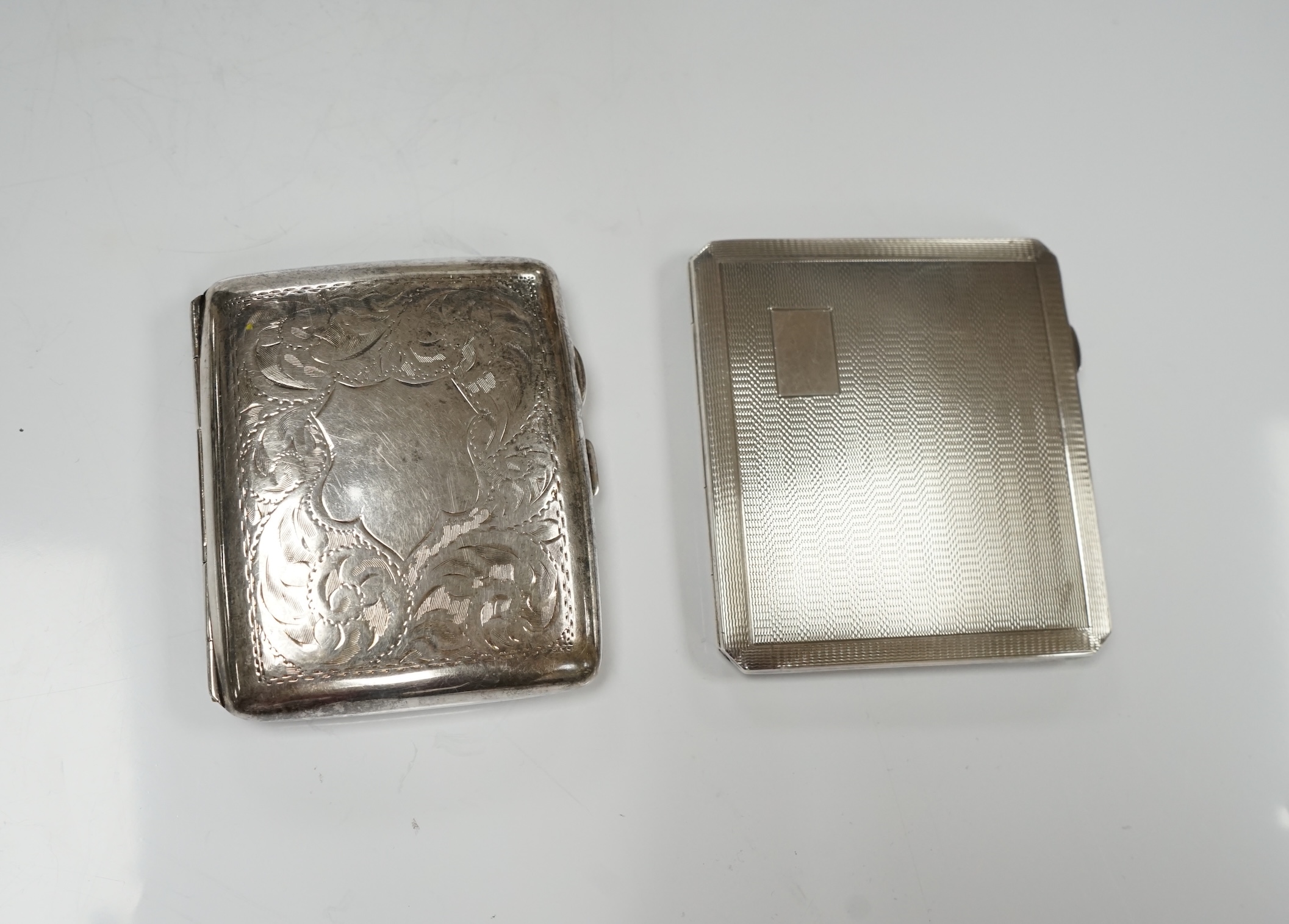 Two silver cigarette cases, a silver plated cigarette case and a Thai? white metal cigarette box, 11.6cm. Condition - poor to fair